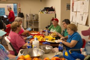 alt=”Community peach peeling station” aria-hidden=”true”